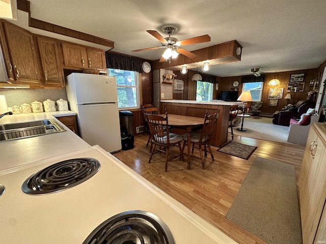 kitchen featuring light countertops, a ceiling fan, freestanding refrigerator, and a sink