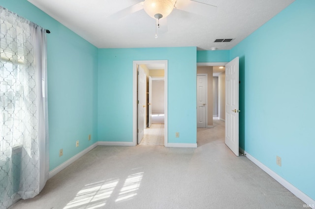 unfurnished bedroom with carpet flooring, baseboards, visible vents, and a ceiling fan