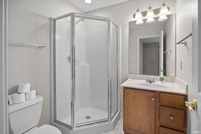 bathroom featuring vanity, a shower stall, and toilet