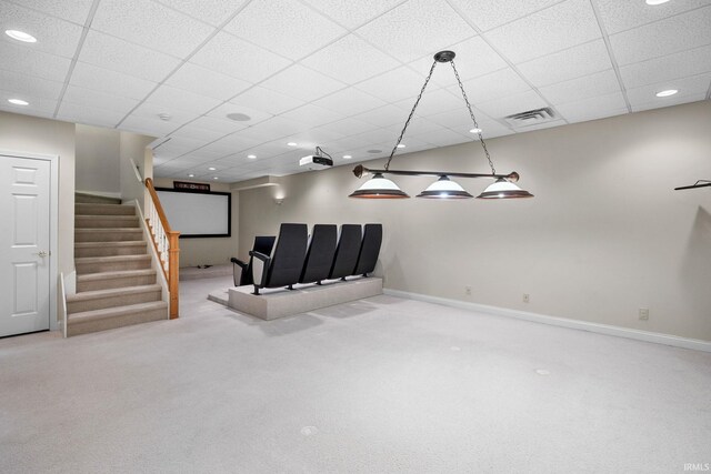 below grade area featuring visible vents, baseboards, stairway, carpet, and a paneled ceiling