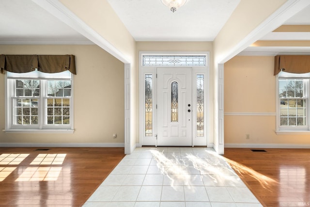 foyer entrance featuring visible vents, baseboards, and wood finished floors