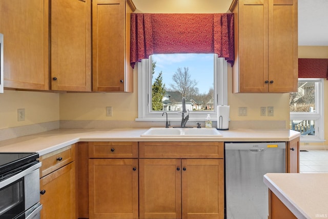 kitchen featuring stainless steel appliances, light countertops, and a sink