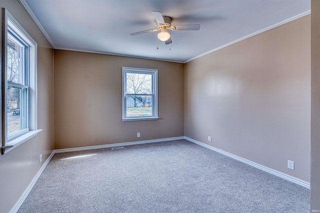 unfurnished room with baseboards, carpet, crown molding, and a ceiling fan