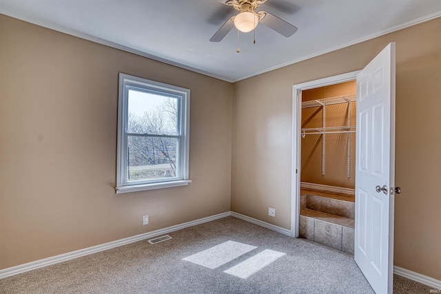 unfurnished bedroom featuring visible vents, carpet floors, baseboards, and ceiling fan