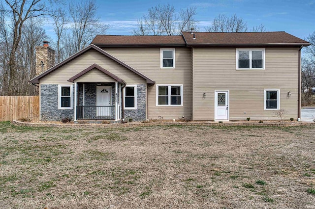 view of front of home with a porch, a front lawn, and fence