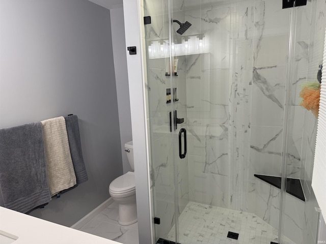 bathroom with a marble finish shower, baseboards, toilet, and marble finish floor