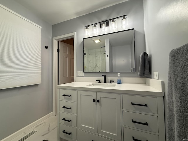 full bath featuring marble finish floor, vanity, a shower, and baseboards