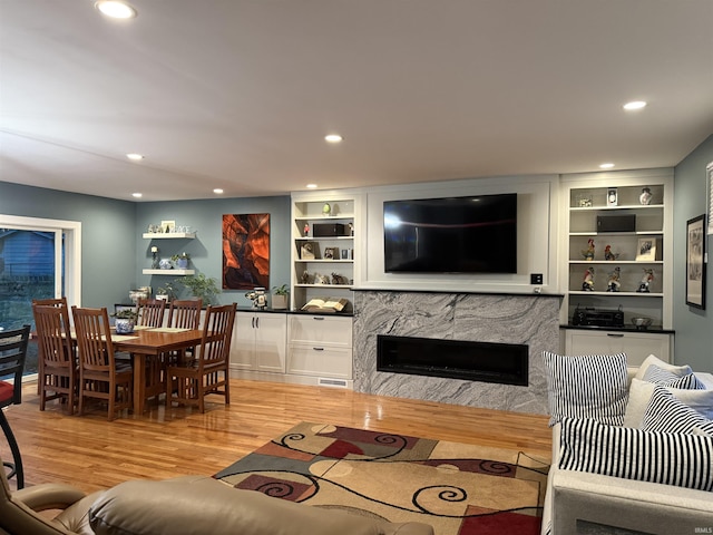 living area with visible vents, recessed lighting, a fireplace, and wood finished floors