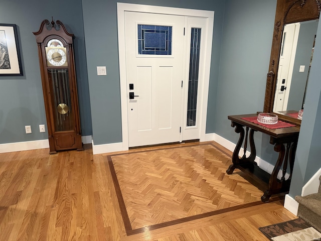 foyer entrance featuring parquet floors and baseboards