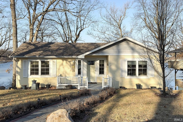 view of front of property with a porch and roof with shingles