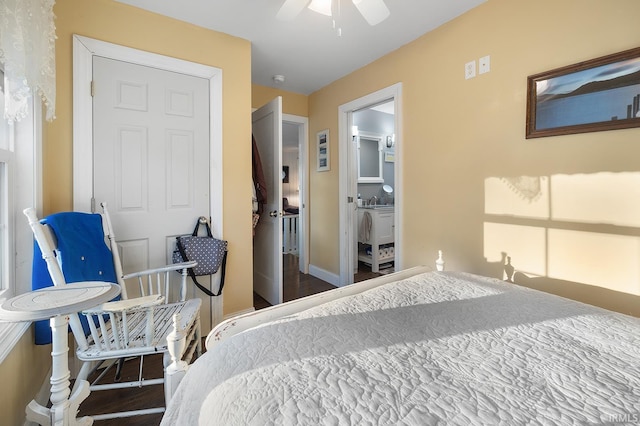 bedroom featuring baseboards, wood finished floors, and ensuite bathroom