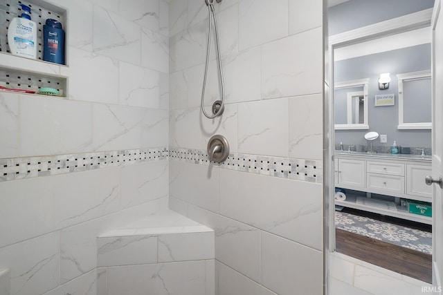 bathroom with vanity and a tile shower