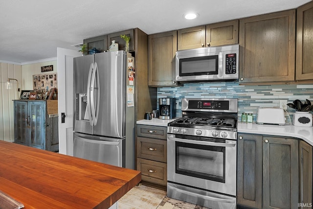 kitchen featuring tasteful backsplash, appliances with stainless steel finishes, and crown molding