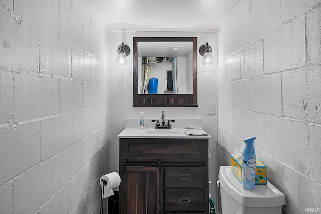 bathroom featuring vanity and concrete block wall