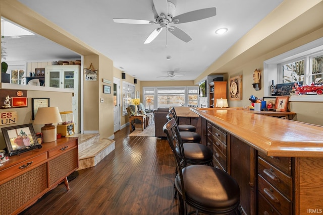 bar with dark wood finished floors, baseboards, and ceiling fan