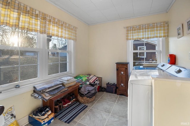 laundry area featuring light tile patterned floors, independent washer and dryer, laundry area, and crown molding