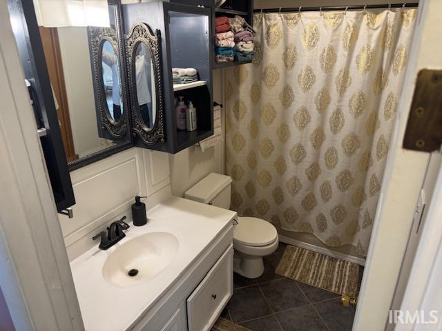 full bathroom with tile patterned floors, a shower with shower curtain, toilet, and vanity