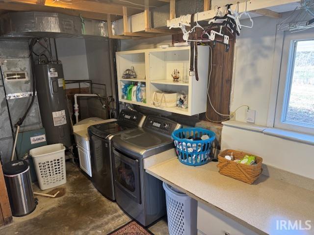 laundry area with laundry area, heating unit, independent washer and dryer, and water heater