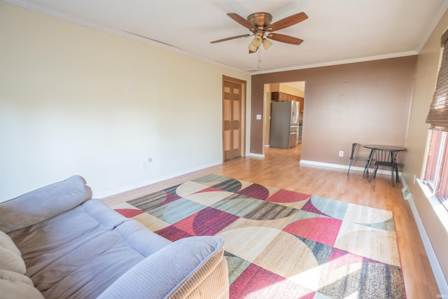 bedroom with baseboards, light wood-style flooring, crown molding, and freestanding refrigerator