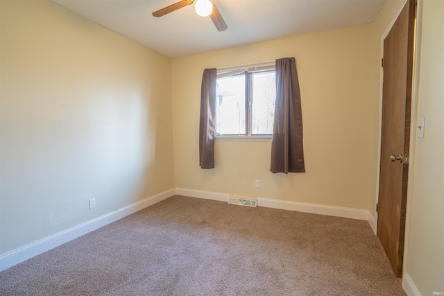 spare room featuring a ceiling fan, visible vents, carpet floors, and baseboards