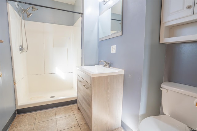 bathroom featuring tile patterned floors, toilet, a shower stall, baseboards, and vanity