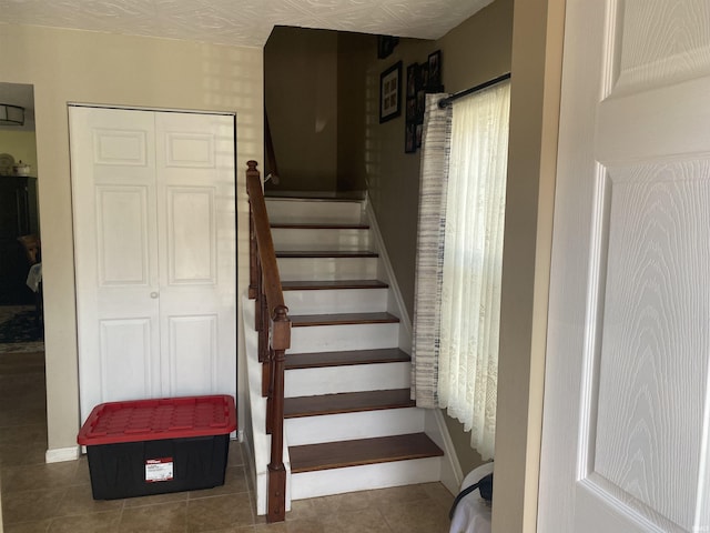 stairway featuring tile patterned floors and baseboards