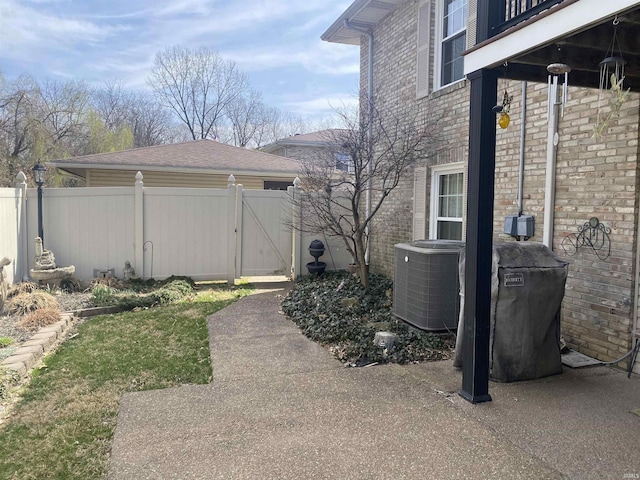 view of yard featuring fence, central AC, and a gate