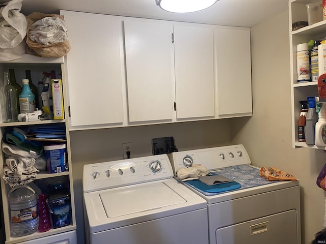 clothes washing area featuring cabinet space and separate washer and dryer