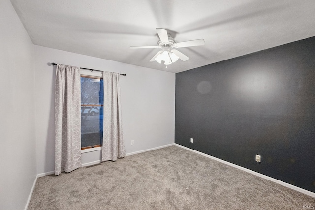 spare room featuring carpet flooring, baseboards, and ceiling fan