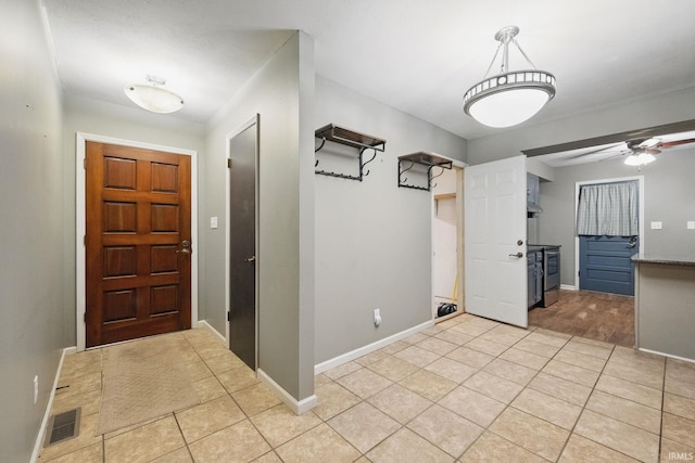 foyer entrance with light tile patterned floors, baseboards, visible vents, and ceiling fan