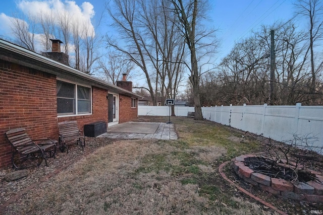 view of yard featuring a patio, a fire pit, and a fenced backyard