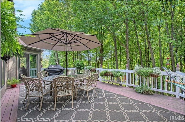 deck with outdoor dining space and area for grilling