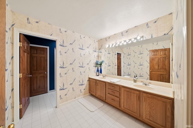 full bathroom with a sink, double vanity, and wallpapered walls