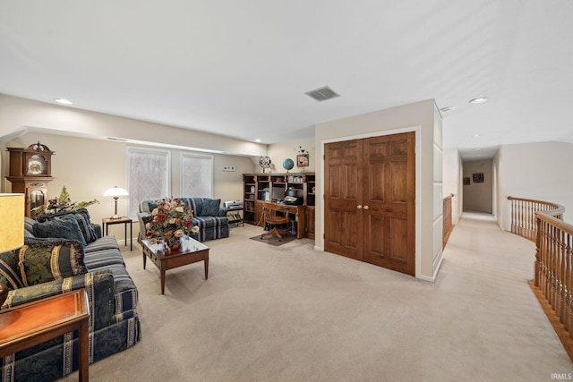 living area with recessed lighting, visible vents, and light carpet