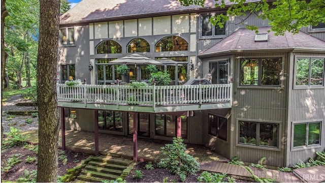 back of property with a wooden deck and a patio area