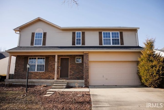 traditional-style home featuring concrete driveway, an attached garage, and brick siding