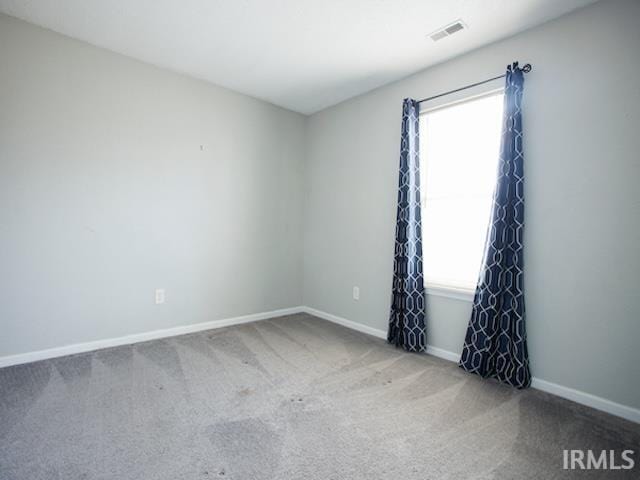 unfurnished room featuring baseboards, visible vents, and carpet floors