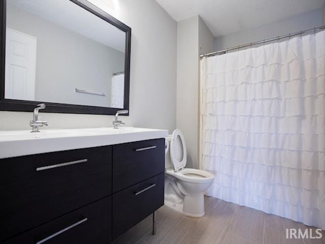 full bath with curtained shower, double vanity, toilet, and a sink