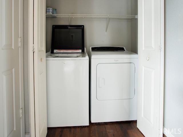 clothes washing area with washer and clothes dryer, laundry area, and dark wood-style flooring