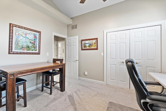 carpeted office space featuring visible vents, baseboards, ceiling fan, and vaulted ceiling