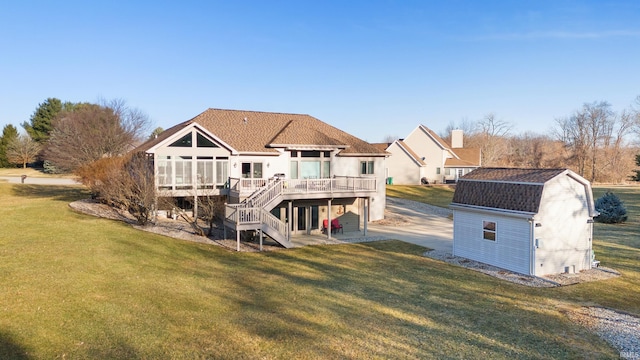 back of property featuring an outbuilding, stairway, a deck, a storage shed, and a lawn