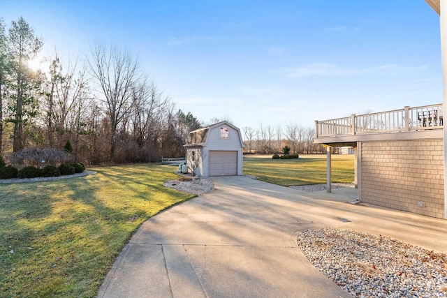 view of yard with a deck, an outdoor structure, concrete driveway, and a garage