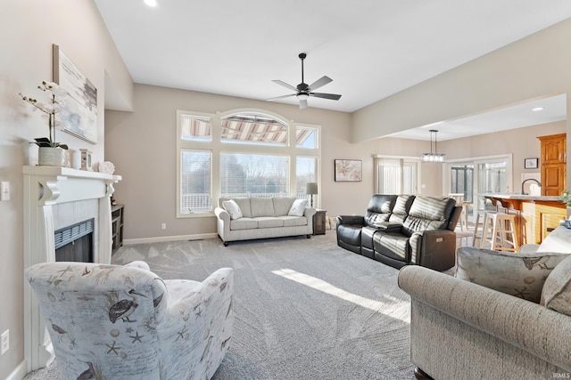 living room featuring light colored carpet, a healthy amount of sunlight, ceiling fan, and a fireplace