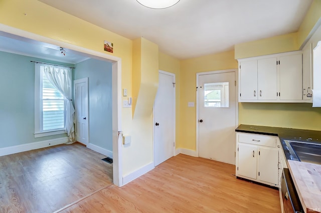 kitchen featuring a wealth of natural light, white cabinets, and light wood-style floors