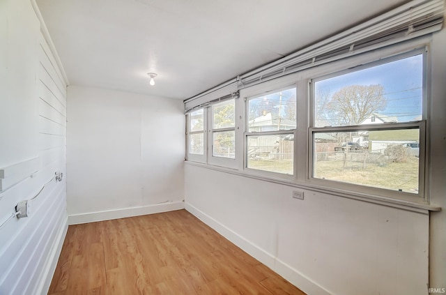 unfurnished room featuring baseboards and light wood-style flooring