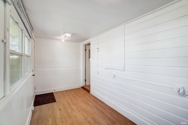 spare room with baseboards and light wood-style floors