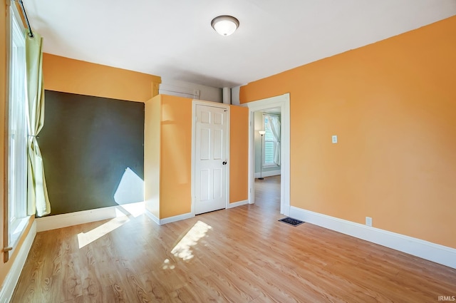 unfurnished bedroom featuring visible vents, baseboards, and light wood finished floors