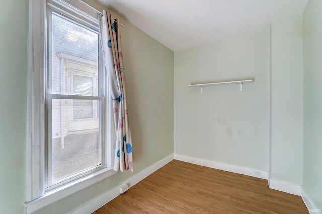 spare room featuring light wood-type flooring and baseboards