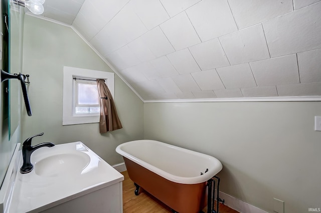 full bathroom with a freestanding tub, wood finished floors, vanity, and vaulted ceiling