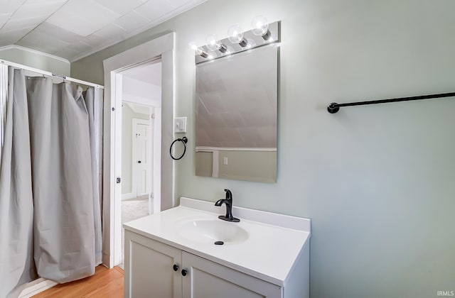 bathroom featuring vanity, crown molding, and wood finished floors